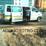 Trotro conductor hops on a bus near Paloma in Accra