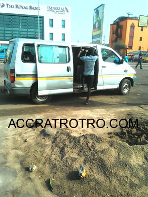 Trotro conductor hops on a bus near Paloma in Accra