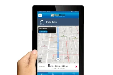 a woman holds a tablet showing a bus app