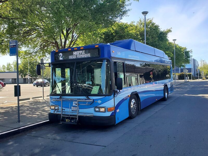 A public bus with a bike holder parks at a stop