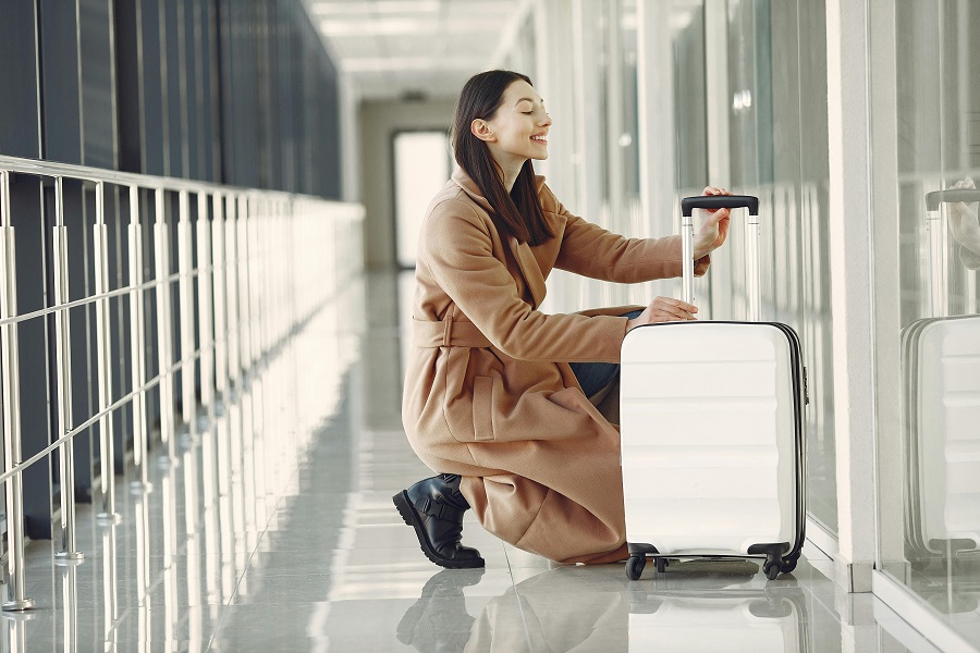 A woman handles her luggage near a storage area