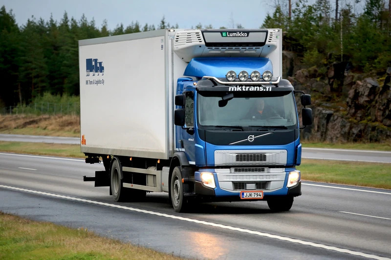 A semi bus trucker drives along a highway