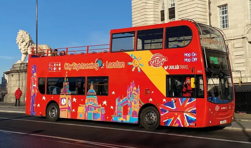 A tourist bus leaves a stop in London