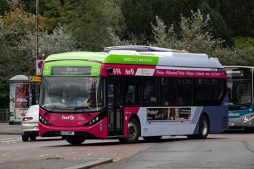 A GLASGOW CITY BUS APPROACHES A STOP