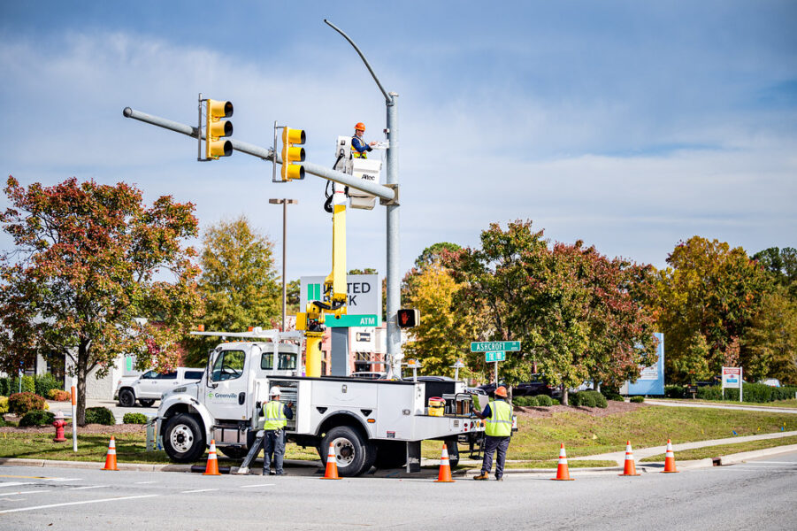 A crew installs a traffic signal control system