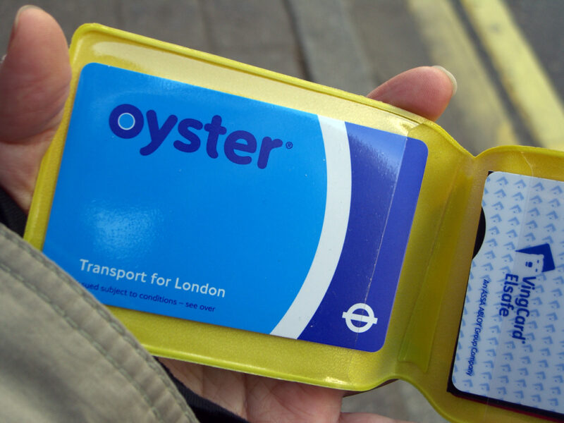 A passenger displays oyster card for buses from a purse